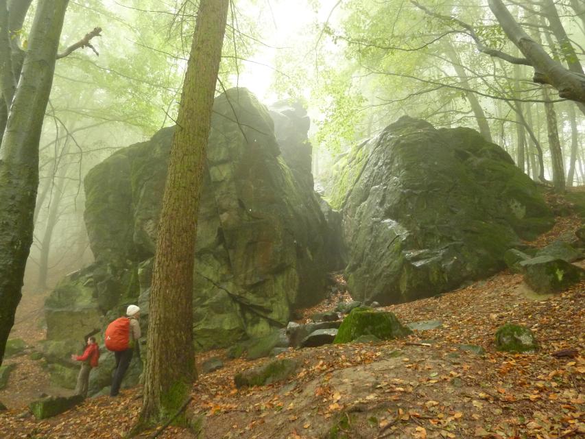 Wanderer am Fuß der Felsformation Magnetsteine in der Nähe von Burg Frankenstein Mühltal.