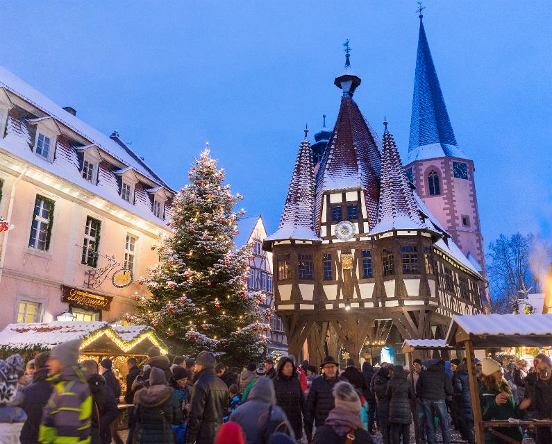 Weihnachtsmarkt mit Weihnachtsmarktbuden und vielen Besuchern vor dem Michelstädter Rathaus im Schnee