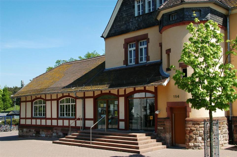 Der Bahnhof in Erzhausen besitzt denkmalgeschütztes Empfangsgebäude. Es wurde aus dem Bahnbesitz ausgegliedert und beherbergt heute die Gemeindebücherei.
                 title=