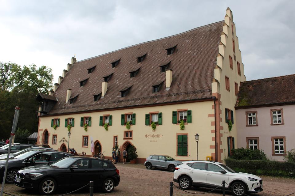 Der markante spätgotische Bau wurde 1448 als Mühle und Bäckerei des Benediktinerklosters errichtet. Mit der Säkularisation fiel das Gebäude an den Fürsten zu Leiningen, der es 1848 verkaufte. Der Mahlbetrieb wurde 1933 eingestellt, noch heute befindet sich aber eine Bäckerei – seit 1953 mit Café – darin.
