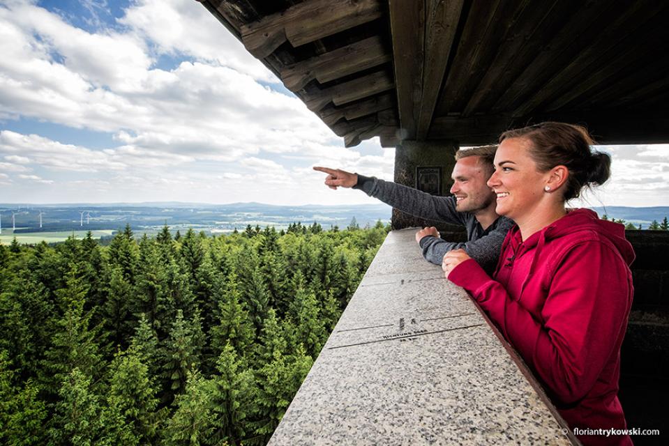 zwei Wanderer schauen von der Schönburgwarte aus in die Natur