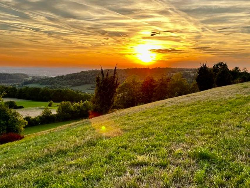 Weiter Blick von einem Hügel in einen Sonnenuntergang