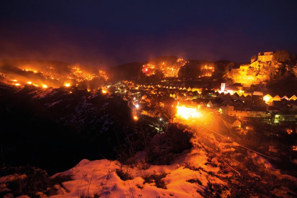 Nachtaufnahme mit brennenden kleinen Feuern rund um Pottenstein