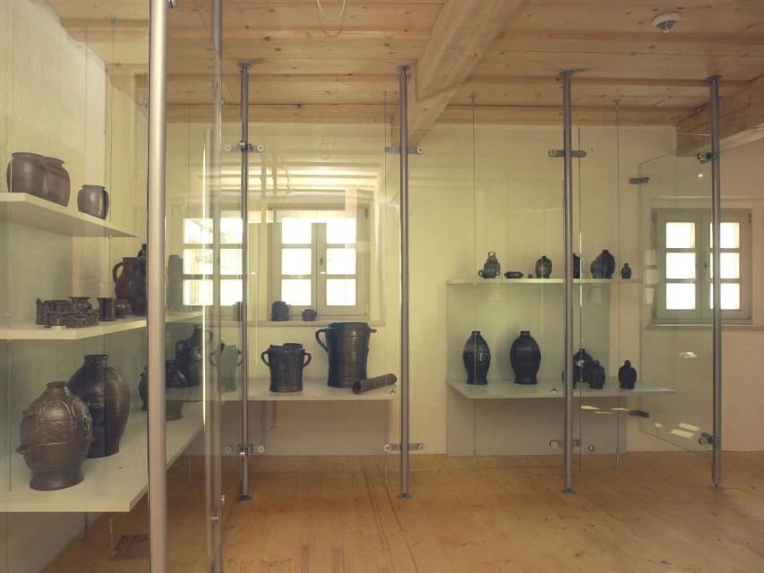 Innenansicht des Museums mit Vitrinen, in denen verschiedene Tonkrüge ausgestellt sind.