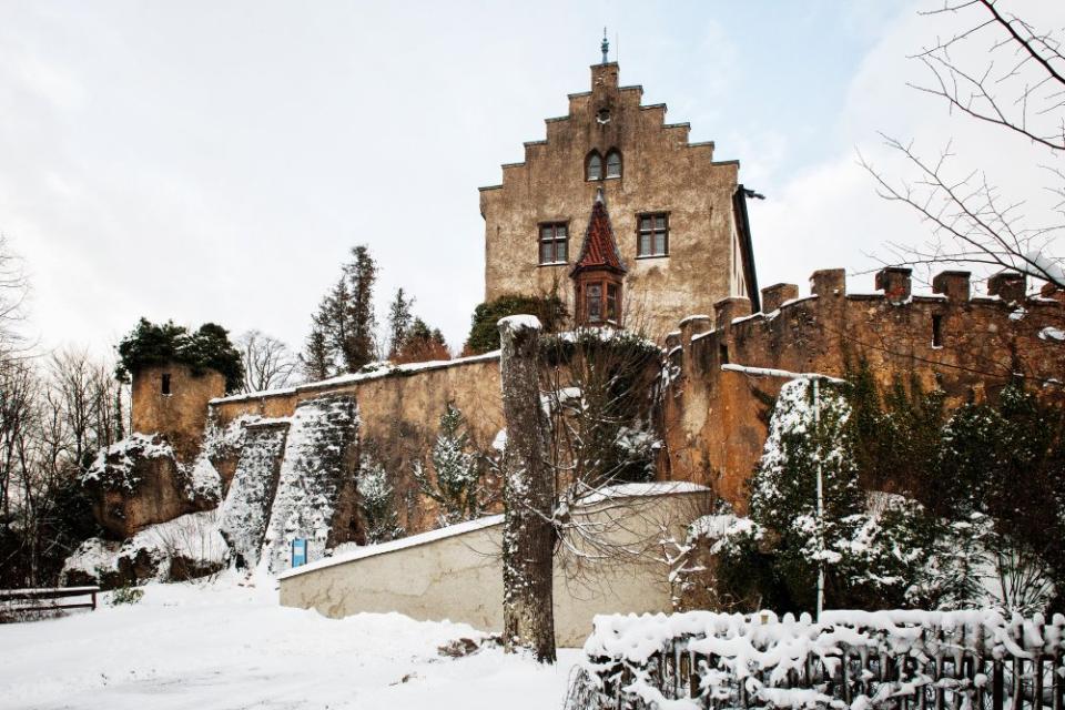 Die mit Schnee verschleierten Burgmauern umringen das historische Gebilde.