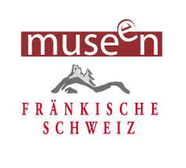 Logo mit weißem Schriftzug "Museen" auf roten Hintergrund. Darunter das eine Silhouette der Runie Neideck in Grau. Darunter der Schriftzug in Rot "Fränkische Schweiz".
                 title=