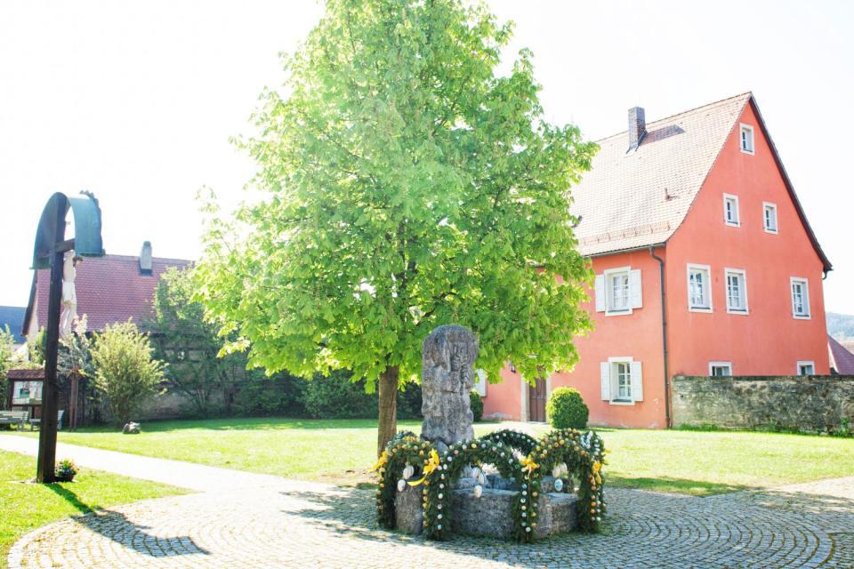 Der Osterbrunnen in Pretzfeld steht im Hof der barocken Pfarrkirche