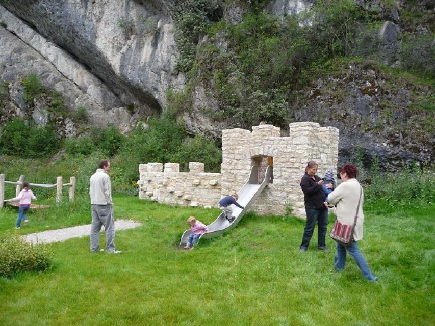 Eine Spielburg mit Rutsche aufgebaut vor einer Felsformation