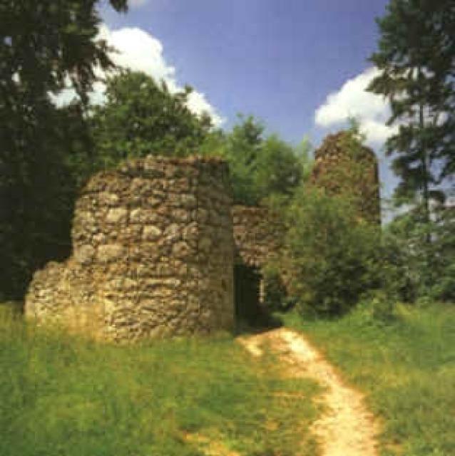 Ein Pfad führt zu den Überresten der ehemaligen Burg. Die Umrisse des Tores und einige Außenwände sind noch zu erkennen.