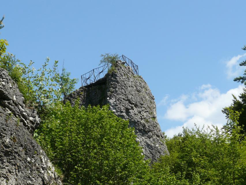 Oberhalb von Baumkronen ragt ein Fels hervor, auf dem vermutlich ein Geländer angebracht ist.
                 title=