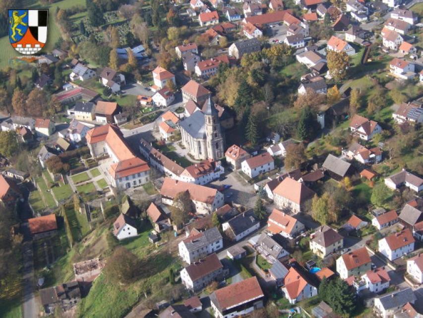 Aus der Vogelperspektive erstreckt sich das Ortsbild Neudrossenfeld zu Grunde. Gut zu erkennen sind das Schloss, die Kirche und eine vielzahl von Häusern des Ortes.