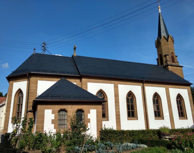 Die katholische Pfarrkirche Kreuzerhöhung wurde von 1862-64 als neugotische Saalkirche mit einem Fassadeneingangsturm und eingezogenem Polygonchor erbaut.Im Jahre 1902 wurde der Kirchenbau erweitert.
                 title=