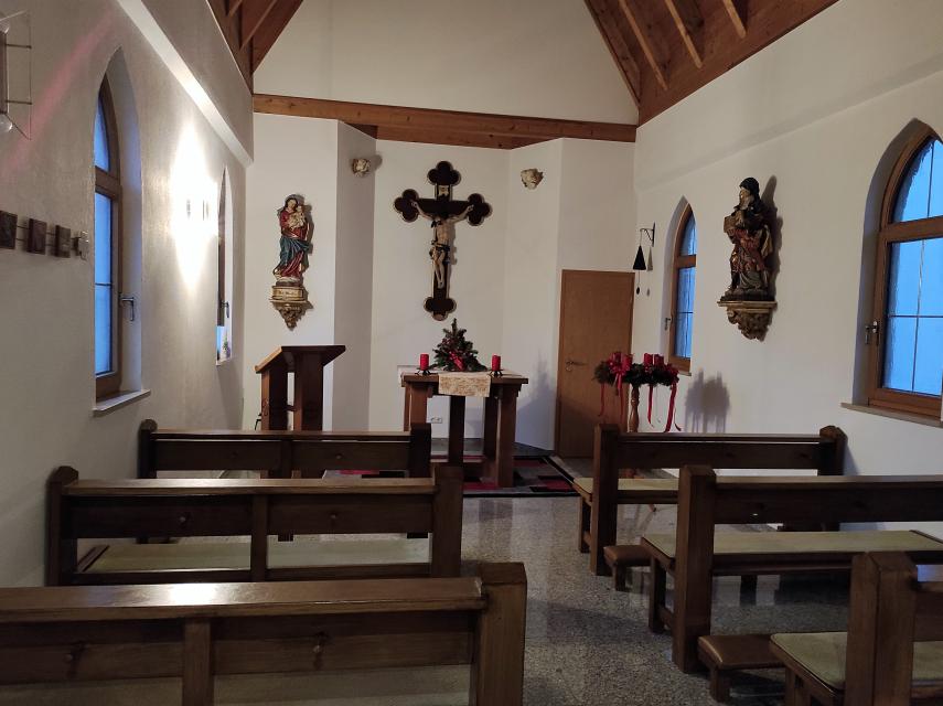 Ein Gang führt an den jeweils drei hölzernen Sitzreihen vorbei zum Altar. Durch wenig Wandbehang ist die Kapelle innen sehr schlicht gehalten.