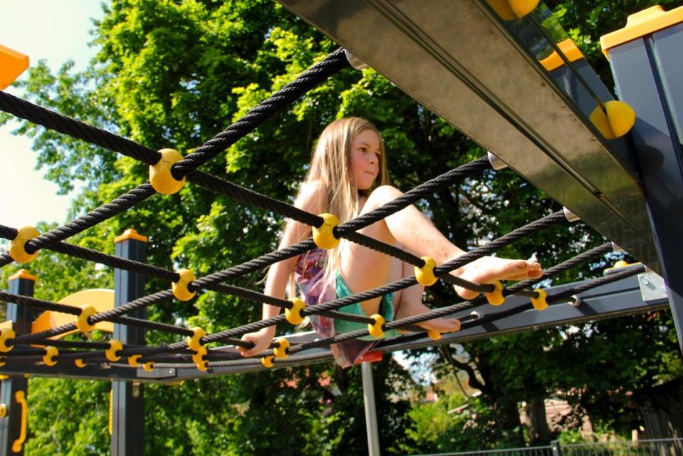 Ein Mädchen klettert in einer Art Netz