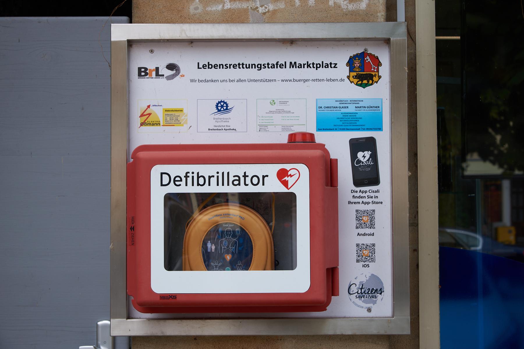 Defibrillator direkt an der Außenwand links neben der Tourist-Info, Nahaufnahme