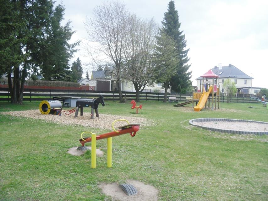 Das Bild zeigt eine Gesamtübersicht des Spielplatzes in Presseck. Es gibt eine Seilbahn, Kletterturm mit Rutsche, Schaukeln; Sandkasten, Sitzgruppen, Wippe.