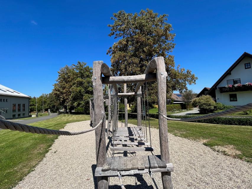 Das Bild zeigt das Klettergerüst am Spielplatz am Freizeit- und Tourismuszentrum in Steinbach am Wald. Man sieht eine Wackelbrücke.
