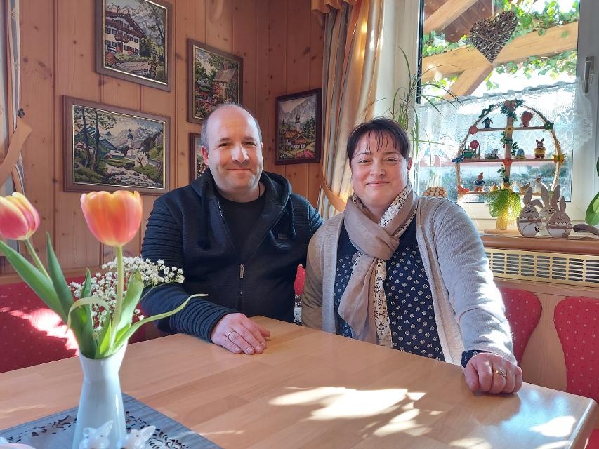 Das Bild zeigt das Ehepaar Fröhmel. Sie sitzen an einem Tisch in ihrem Gasthof Roseneck