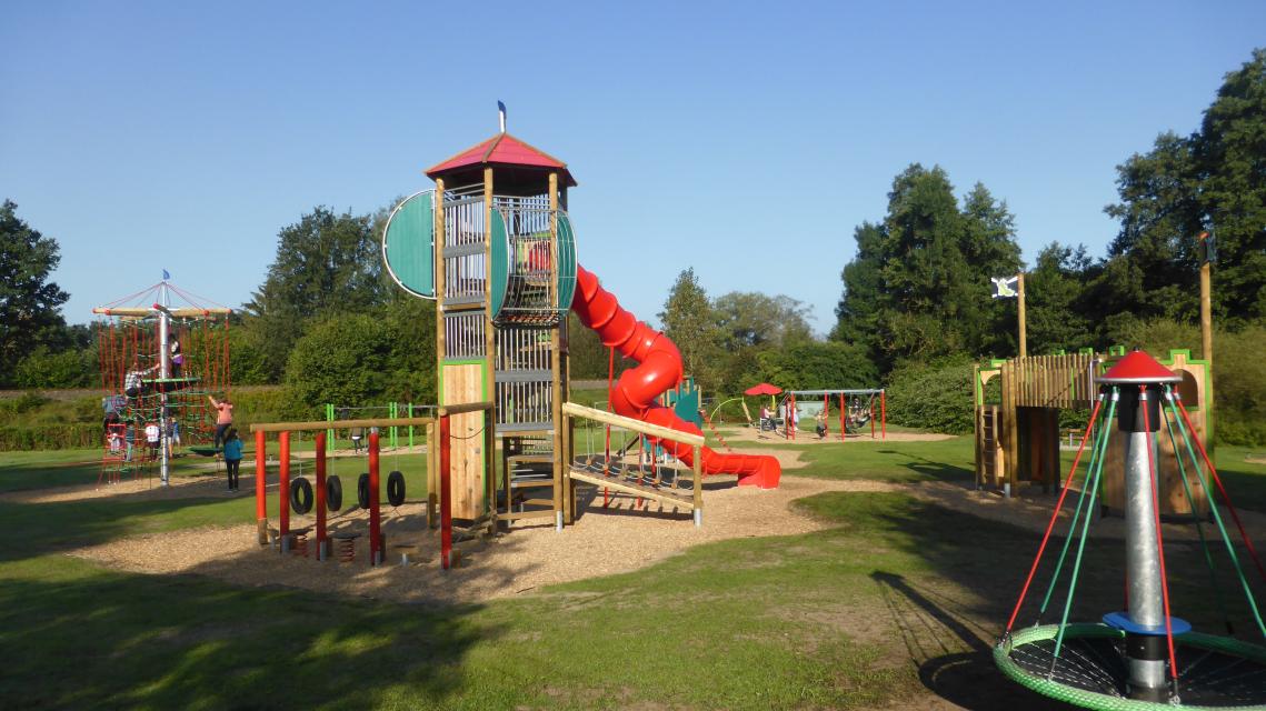 Blick auf den Drachen-Spielpark mit Kletterturm und Röhrenrutsche im Bildmittelpunkt