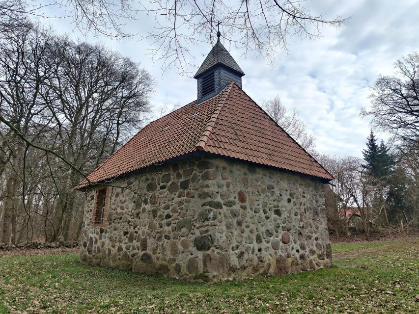 Rückseite der kleinen, rechteckigen Felsteinkapelle in Müssingen mit rotem Ziegeldach und kleinem hölzernen Dachreiter