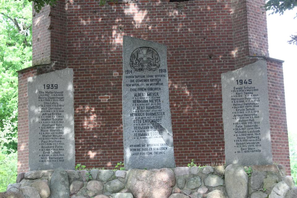 Drei Stelen mit Namen von Gefallenen des Ersten und zweiten Weltkrieges, auf über stufen erreichbaren Findlingssockel.