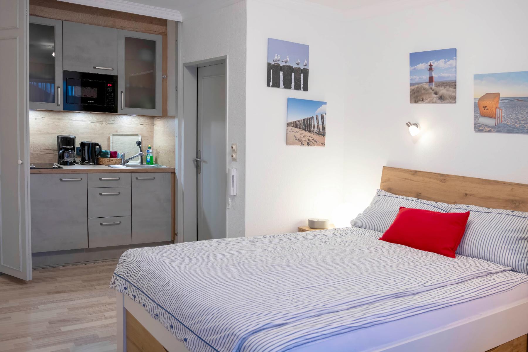 Schlafbereich mit Doppelbett und Küchenzeile in der Ferienwohnung Uhlennest Bad Bevensen