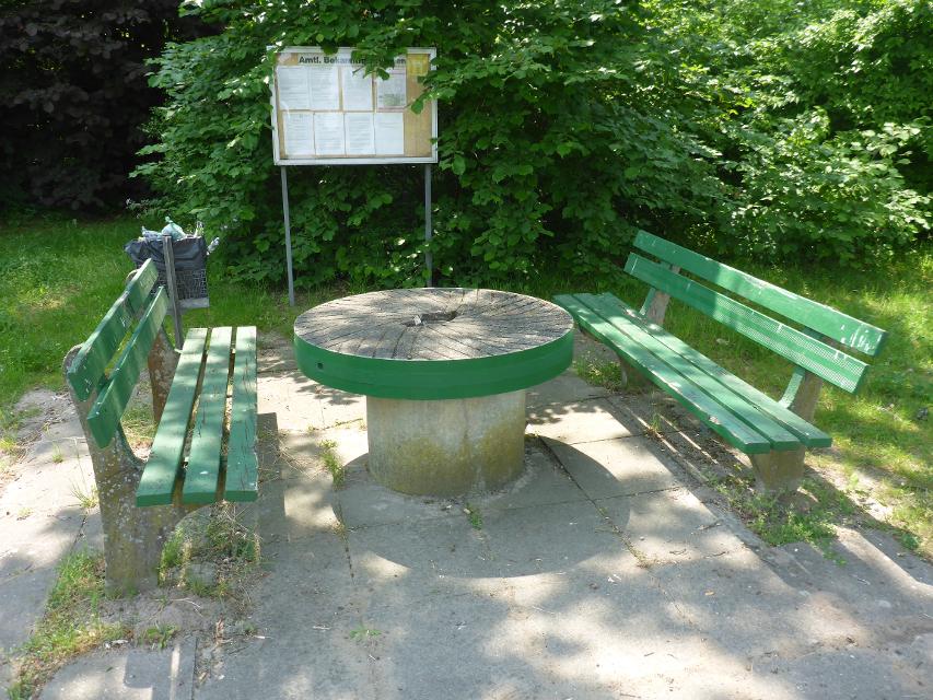 In der Dorfmitte von Molbath lädt ein kleiner Rast- und Picknickplatz zum Verweilen ein. Ein alter Mühlstein dient als Tisch.