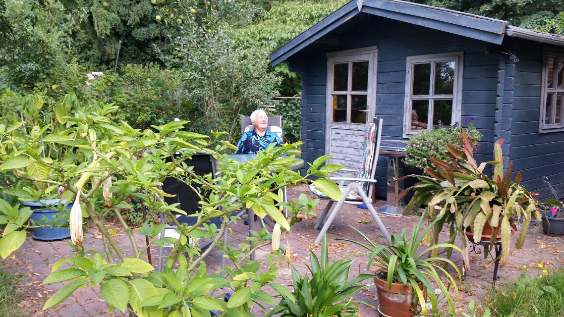 Konventualin Borcherding in ihrem Garten vor einem blauen Gartenhaus