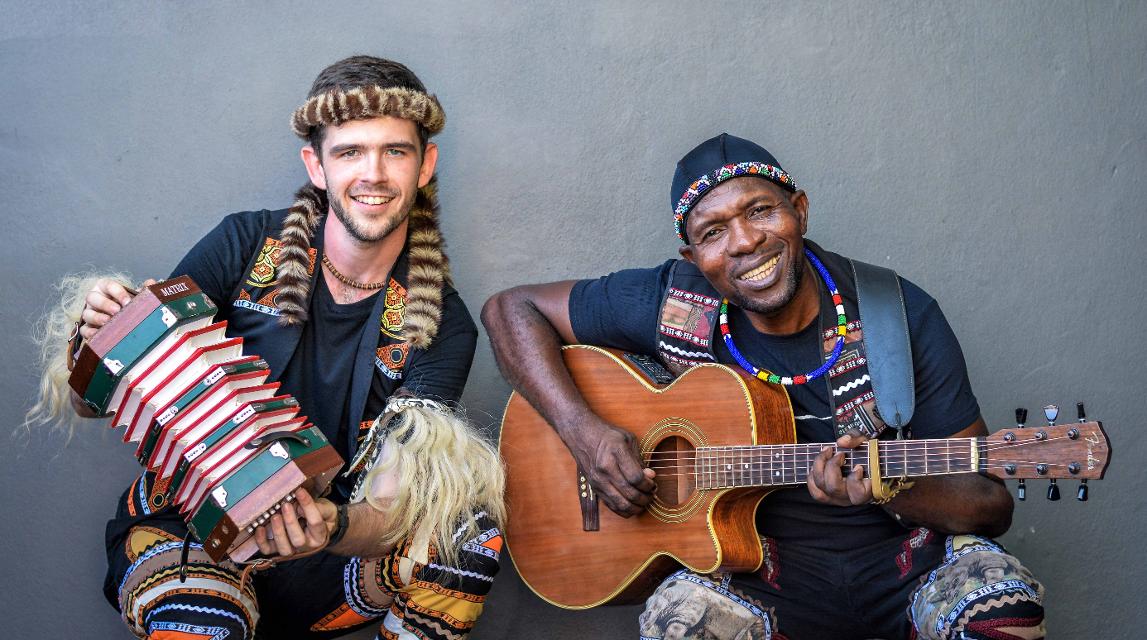 Musik kennt keine Hautfarbe: Qadasi (steht in Zulu für der „Weiße“) & Maqhinga leben das seit Jahren mit ihrer Folkmusik. Beide sind Botschafter der traditionellen Maskandi-Musik, die ihre Wurzeln in der Kultur der Zulus hat und erobern die internationalen Bühnen dieser Welt. David Jenkins (Qadasi) entdeckte als 10jähriger seine Leidenschaft für die Sprache und der Musik der Zulu: In Empangeni nahe der Großstadt Durban aufgewachsen, begleitete er seinen Vater, einen Journalisten, auf seinen Reportagereisen durch das Zululand. David brachte sich selbst das Gitarrespielen bei und setzte gegen Widerstände durch, in der Schule die Sprache der Zulus zu lernen und nicht Afrikaans, das der Schuldirektor im Post-Apartheid Zeitalter Südafrikas noch immer für einen Weißen als einzig angemessene Sprache empfahl… 2010 lernte David Jenkins (Qadasi) dann Maqhinga Radebe kennen: „Meister“ Maqhinga, der als Maskandi-Gitarrist bereits seit den 1980er Jahren einen herausragenden Ruf hatte, stimmte Davids neues Instrument, die klassische Concertina und wurde Davids Mentor.Ihre Musik vereint, versöhnt, begeistert, überwindet Grenzen, bewegt….Ein wahres Sommer-Highlight, zu dem die Ev.-luth. Gesamt-Kirchengemeinde Bevensen-Medingen, der Südafrika-Partnerschaftskreis und das Ev.-luth. Kita-Zentrum Bad Bevensen im Rahmen seiner Jubiläumswoche einladen!Eintritt frei, Spenden erwünscht!