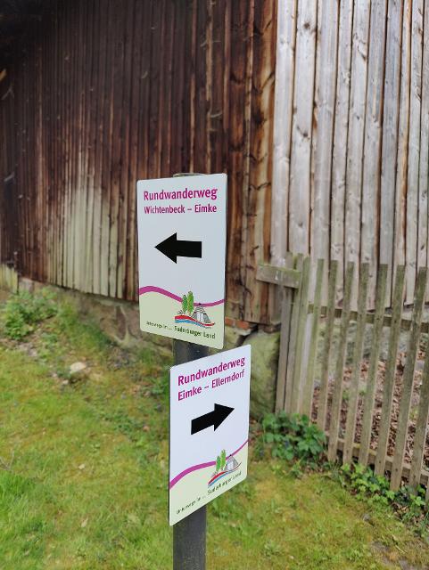 Zwei kleine Schilder mit Wegweisung Rundweg Wichtenbeck Eimke