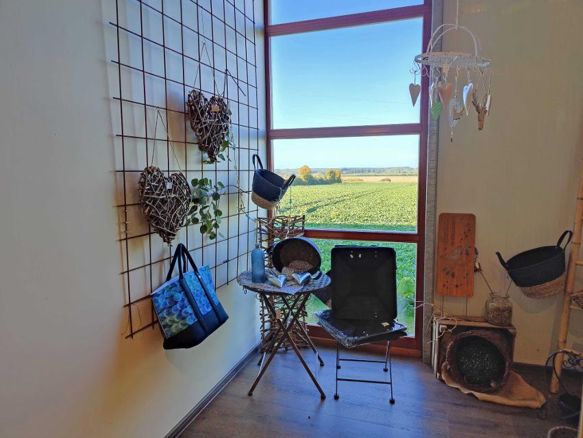 Deko Ecke in der Obstscheune mit Aussicht auf Felder durch großes Fenster