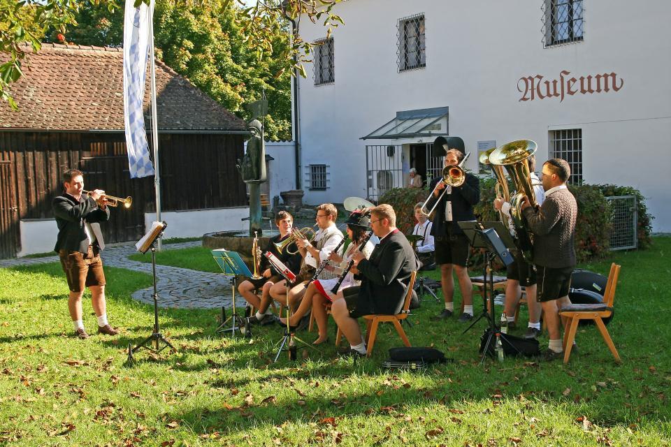 Eine Blaskapelle spielt zünftig auf vor dem Kreismuseum Bogenberg.
