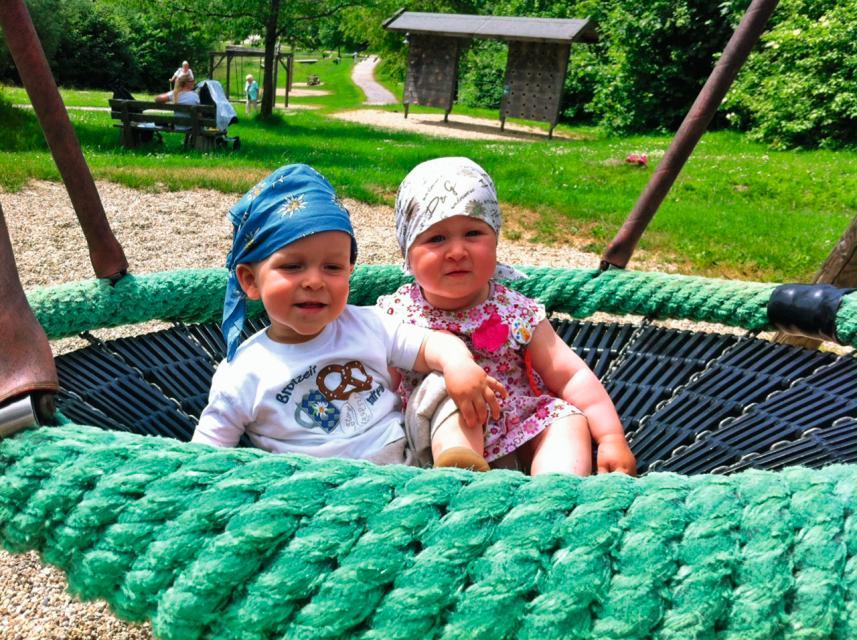 Zwei Kleinkinder vergnügen sich gemeinsam im Vogelnest, einem der vielen Spielgeräte bei der Spielmeile im Kurpark Sankt Englmar.
