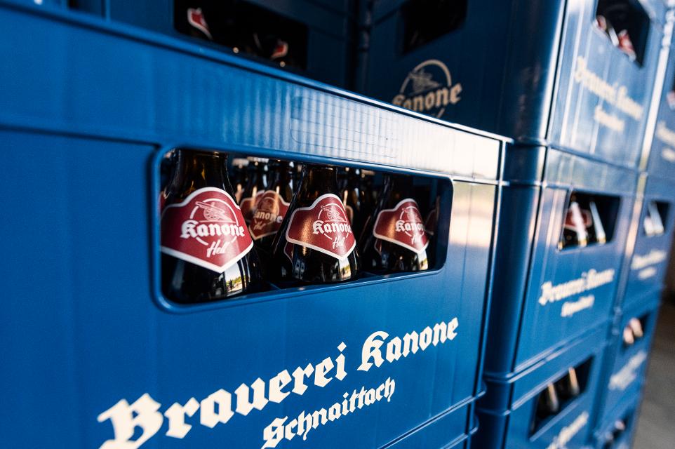 Blaue Bierkästen mit Bierflaschen Kanone Hell, rotes Etikett im Lager der Brauerei Kanone