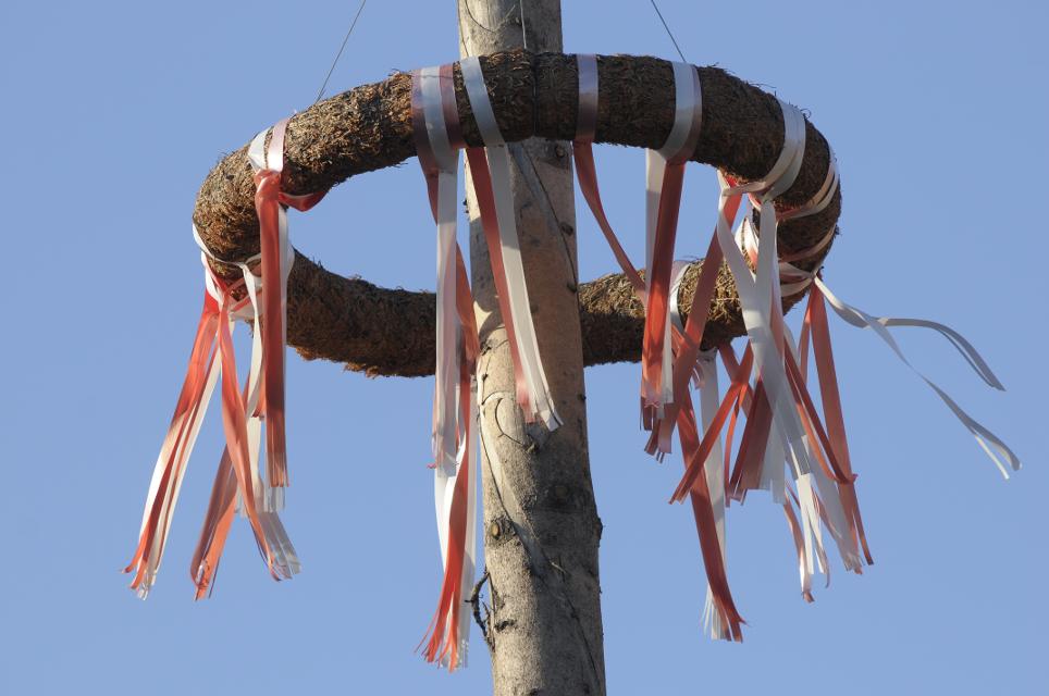 Kranz mit roten und weißen Bändern am Baum