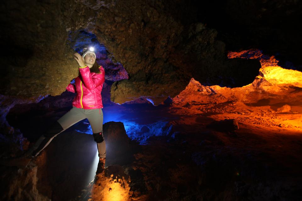 Junge Frau in Wanderbekleidung mit Stirnlampe in der Petershöhle