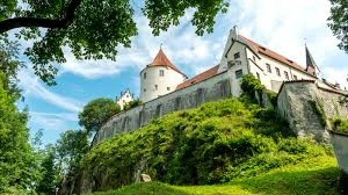 Der Besucher blickt hinauf zum Schloss mit seiner Mauer und den Türmen.