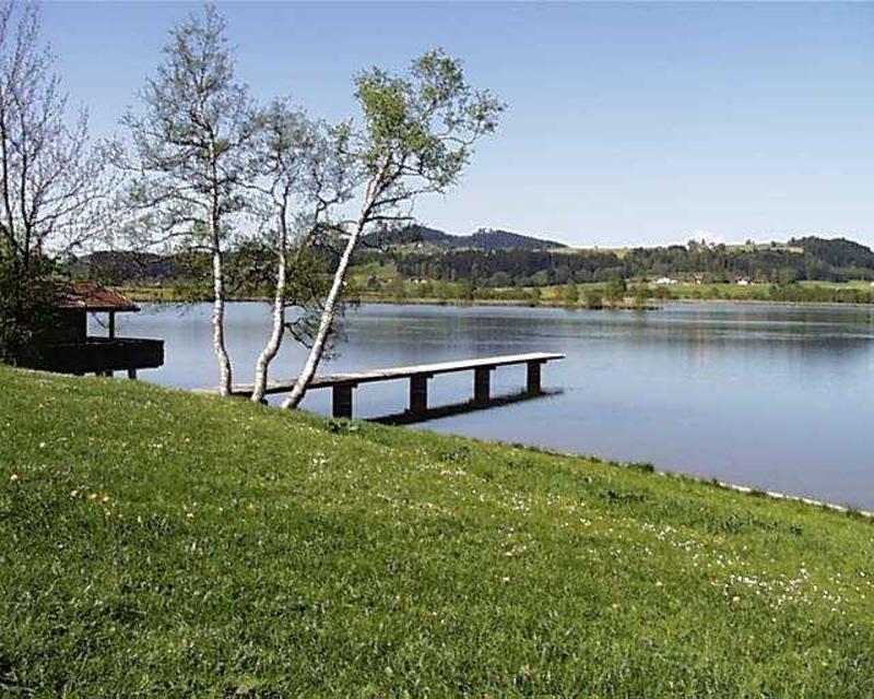 Der eher unbekannte Haslacher See liegt bei Bernbeuren am Fuße des Auerberges inmitten einer malerischen Landschaft. Der Auerberg ist mit seinen 1055 Metern die einzige Erhebung in der Umgebung und markiert schon von Weitem den versteckten See.
