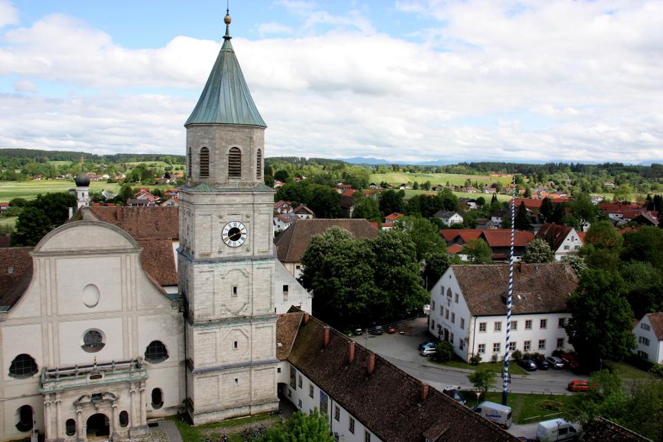 Der Betrachter blickt von oben auf die Klosterkirche mit Kirchturm und der Klosterwirtschaft.