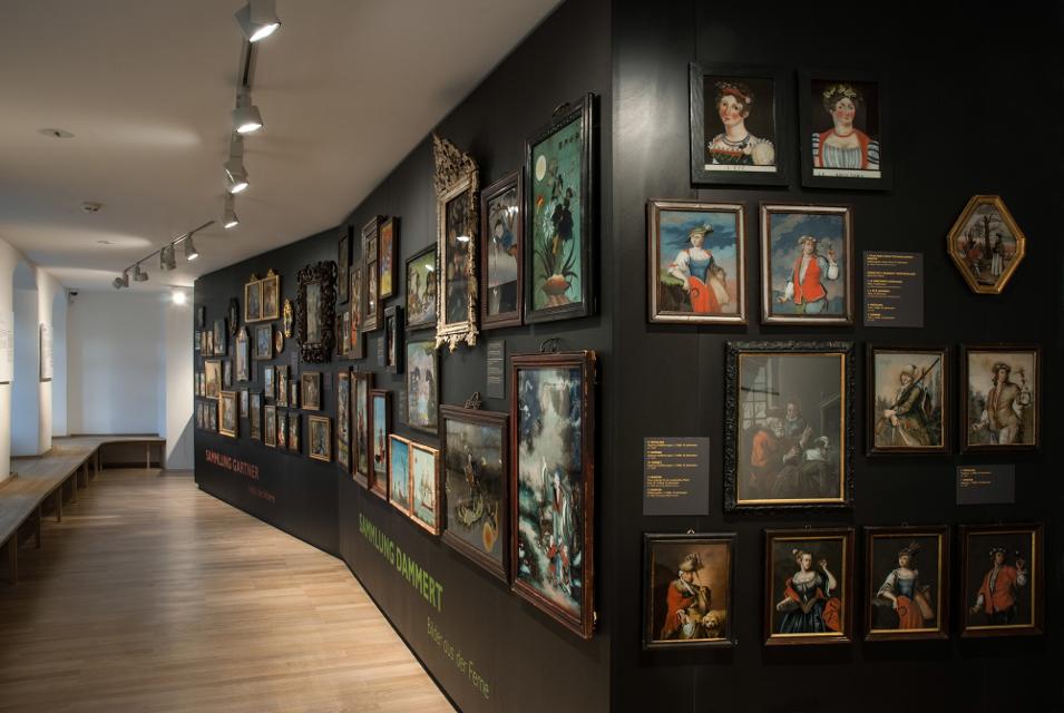 Die gesamte Wand im Museum ist komplett mit Hinterglasbildern behängt.