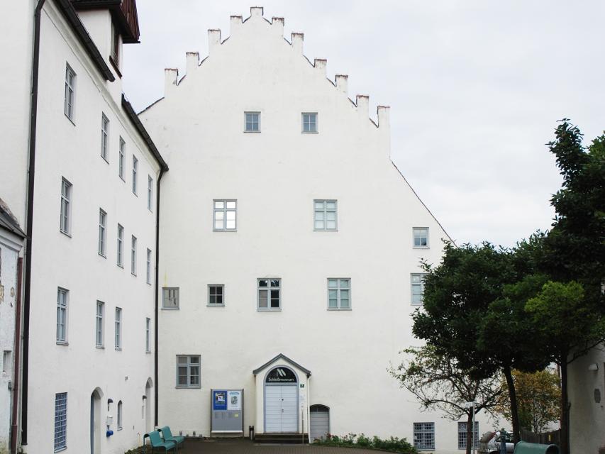 Der Blick führt direkt an der Straße entlang auf das große imposante weiße Gebäude des Schlossmuseums.