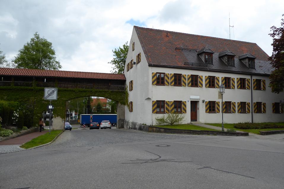 Der Besucher steht vor einem historischen Gebäude das in die Stadtmauer integriert ist. Links davon ist das große Münztor zu sehen.