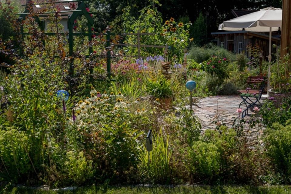Der Besucher befindet sich in einem liebevoll angelegten Garten mit Dekoration.