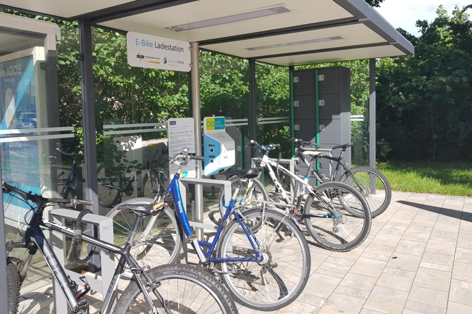 Ladestation mit Anschlüssen für 5 E-Bikes, 10 verschließbare Gepäckboxen mit Lademöglichkeit, überdachte Fahrradparkplätze