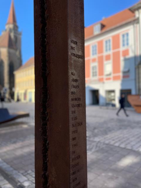 Die senkrechte, schlanke Stahlsäule wurde am 23. Mai 2017 enthüllt. Sie erinnert an die Menschen, die sich zur Zeit des Nationalsozialismus mit viel Mut gegen das Unrechtsregime gestemmt haben. Der tiefe Einschnitt in die Skulptur verlieh ihr i...