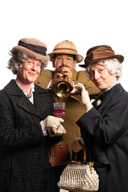 Zwei ältere Damen, ein Herr mit Trompete in der Mitte