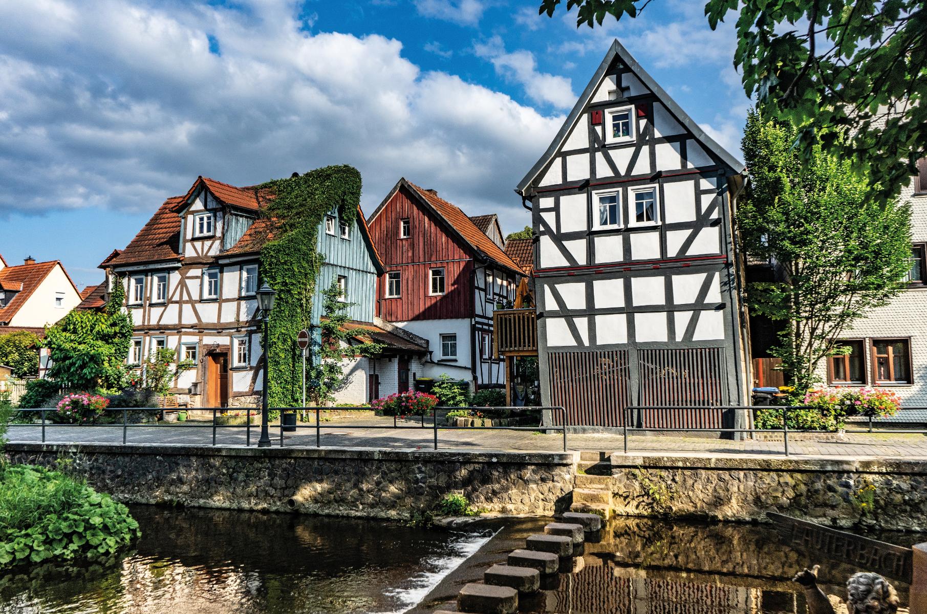 Die Lauter im hessischen Lauterbach im Vogelsberg kann man zu Fuß über die Schrittsteine überqueren. Das Ufer ist gesäumt von Fachwerkhäusern.