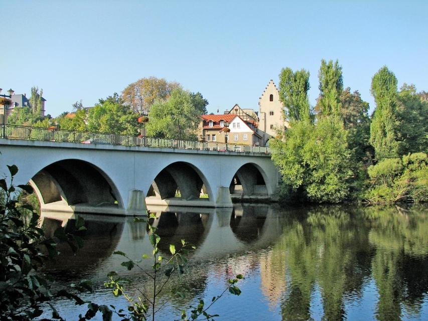 Die Brücke verbindet die Altstadt mit dem Stadtteil Altsaalfeld. Erstmalig im 14. Jahrhundert als schmales einspuriges Bauwerk erwähnt, war sie dem zunehmenden Verkehr nicht mehr gewachsen, stellte sie doch die einzige Verbindung zwischen der Altstadt und dem Industrieviertel dar. Man ersetzte si...